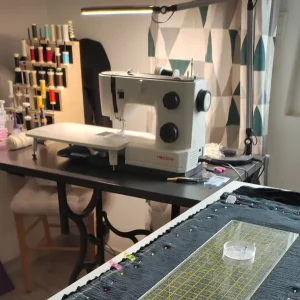Atelier Fil Dé Toile avec machine à coudre, bobines de fils et tissu en cours de confection