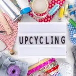 Icône illustrant l’upcycling avec boîte lumineuse et matériel créatif – Fil Dé Toile