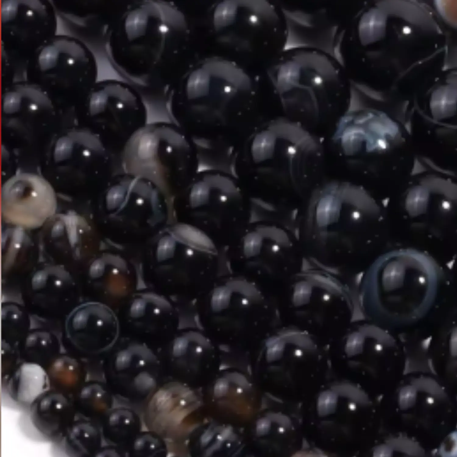 Perles d’agate noire naturelle aux reflets sombres et brillants, utilisées pour des bijoux en macramé artisanaux Fil Dé Toile