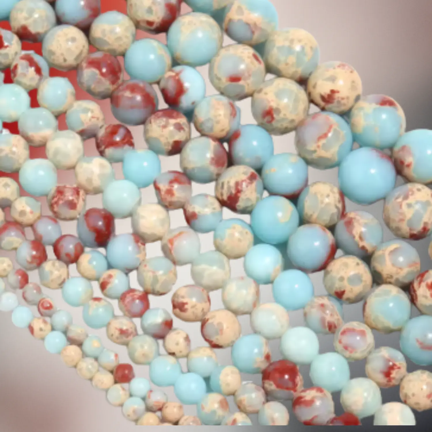 Perles de jaspe aqua terra aux tons bleu turquoise, beige et rouge, utilisées pour des bijoux en macramé artisanaux Fil Dé Toile