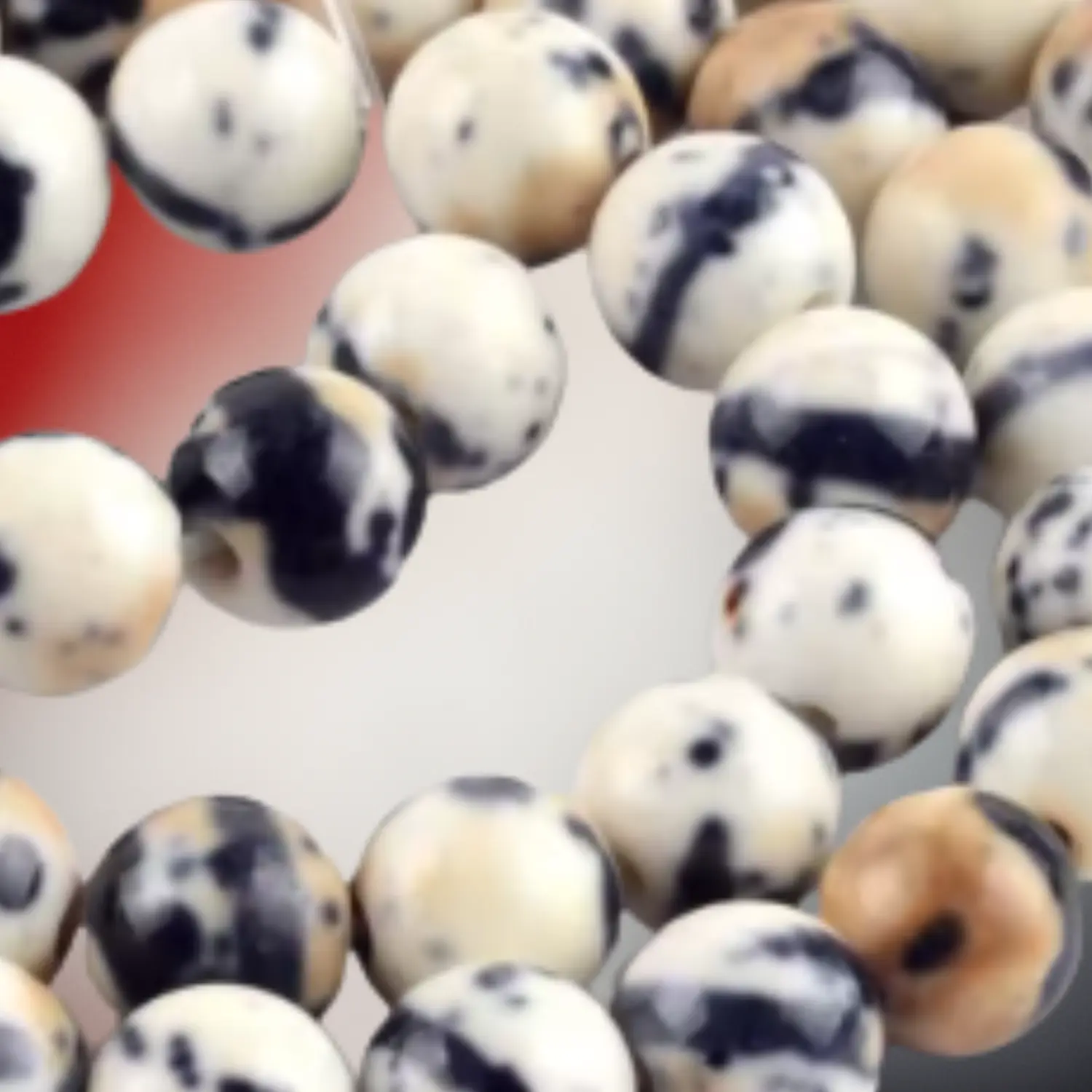 Perles de jaspe dalmatien aux tons crème ponctués de noir, utilisées pour des bijoux en macramé artisanaux Fil Dé Toile